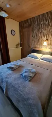 a bedroom with two beds and a clock on the wall at Apartamentai pas Danutę in Prienai