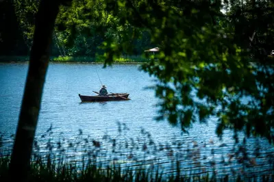 a man is in a boat on a lake at VieniKrante in Utena