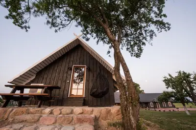 a small church with a cross on the roof at Family house Vila Rica in Ricieliai