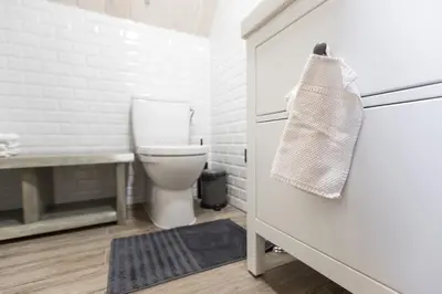 a bathroom with a toilet and a towel on the door at Family house Vila Rica in Ricieliai