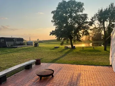 a bench and a table on a brick path in a park at Family house Vila Rica in Ricieliai