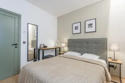 a bedroom with a large bed and two tables with lamps at COME2rest - Stikliu 20 in Vilnius