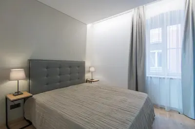 a bedroom with a bed and a large window at COME2rest - Stikliu 20 in Vilnius