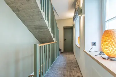 a hallway with a staircase with green railings at COME2rest - Stikliu 20 in Vilnius