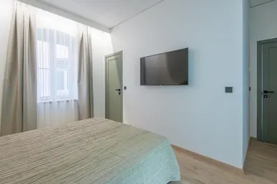 a bedroom with a bed and a flat screen tv at COME2rest - Stikliu 20 in Vilnius