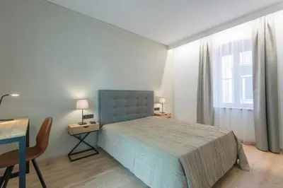 a bedroom with a bed and a desk and a window at COME2rest - Stikliu 20 in Vilnius