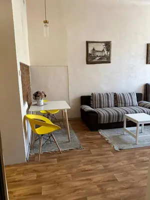 a living room with a couch and a table and yellow chairs at Sija's house in Kaunas
