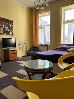 a bedroom with a bed and a table and a tv at Sija's house in Kaunas