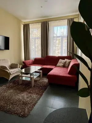 a living room with a red couch and a table at Sija's house in Kaunas