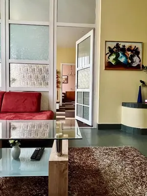 a living room with a red couch and a mirror at Sija's house in Kaunas