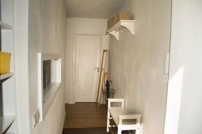a hallway with white walls and a staircase with two white chairs at A perfect base to explore Vilnius! in Vilnius