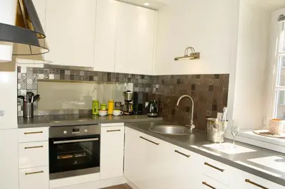 a kitchen with white cabinets and a sink at A perfect base to explore Vilnius! in Vilnius