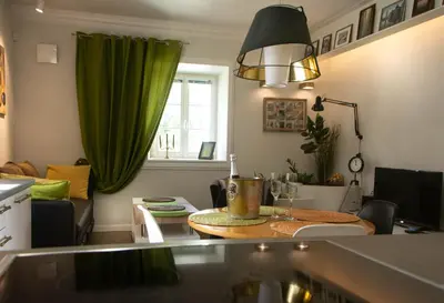 a living room with a table and a green curtain at A perfect base to explore Vilnius! in Vilnius