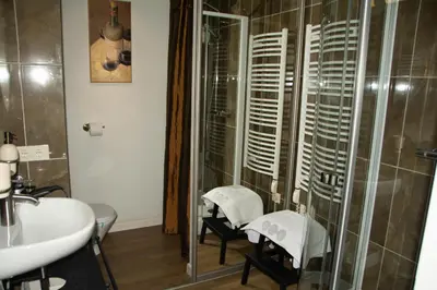 a bathroom with a shower and two chairs and a sink at A perfect base to explore Vilnius! in Vilnius