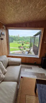 a living room with a couch and a large window at Scent yard in Marijampolė