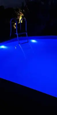a swimming pool with blue lights in the dark at Scent yard in Marijampolė