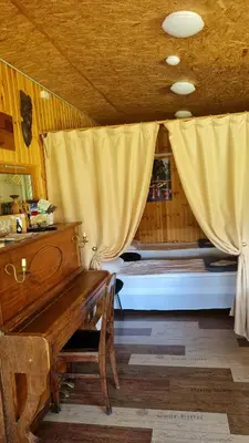 a room with a bench and a bed with curtains at Scent yard in Marijampolė
