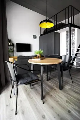 a dining table and chairs in a living room at G - Owl Jazz -Modern loft type apartment 18 with big roof terrace and free private parking in Kaunas