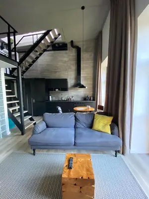 a living room with a blue couch and a wooden table at G - Owl Jazz -Modern loft type apartment 18 with big roof terrace and free private parking in Kaunas