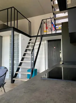 a staircase in a living room with a stair case at G - Owl Jazz -Modern loft type apartment 18 with big roof terrace and free private parking in Kaunas