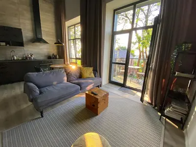 a living room with a couch and a table at G - Owl Jazz -Modern loft type apartment 18 with big roof terrace and free private parking in Kaunas