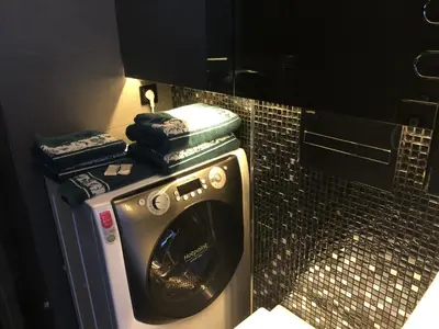a washing machine in a bathroom with a tiled wall at Modern and Luxury Apartment in the Center of Kaunas in Kaunas