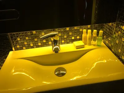 a yellow sink in a bathroom with a mirror at Modern and Luxury Apartment in the Center of Kaunas in Kaunas