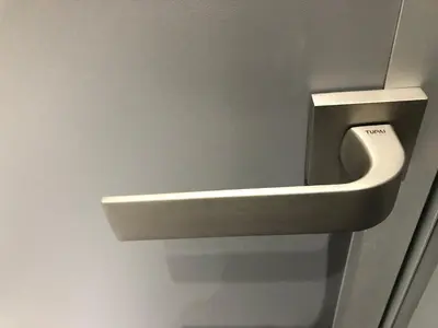 a bathroom door with a urinal on the wall at Modern and Luxury Apartment in the Center of Kaunas in Kaunas