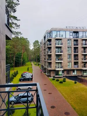 a balcony of a building with cars parked on a street at Modern boutique apartment in the city center in Druskininkai