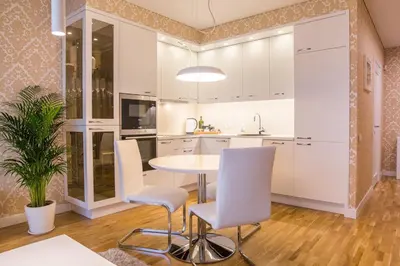 a kitchen with white cabinets and a table and chairs at Antakalnis 5 stars apartment in Vilnius
