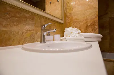 a white sink in a bathroom with a mirror and towels at Antakalnis 5 stars apartment in Vilnius
