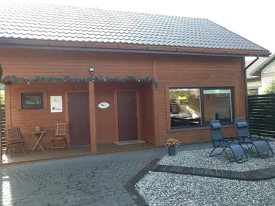 a house with a patio and a table and chairs at Mini spa Harmonija in Zapyškis