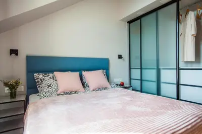 a bedroom with a large bed with two pink pillows at Penthouse in the City Center in Vilnius