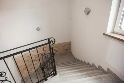 a staircase with a metal railing next to a window at Penthouse in the City Center in Vilnius
