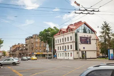 a building on a city street with cars on the road at Penthouse in the City Center in Vilnius