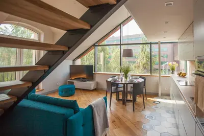 a living room with a blue couch and a table at Penthouse in the City Center in Vilnius