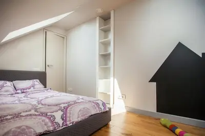 a bedroom with a bed and a black wall at Penthouse in the City Center in Vilnius
