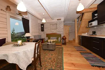 a living room with a table and a kitchen at Kliukai in Dubingiai