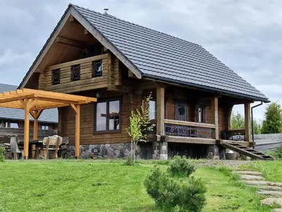 a large wooden house with a gambrel roof at Namukas su ežero pakrante Trakai ,Viesų vila in Salkininkai