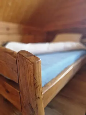 a close up of a wooden bed in a room at Namukas su ežero pakrante Trakai ,Viesų vila in Salkininkai