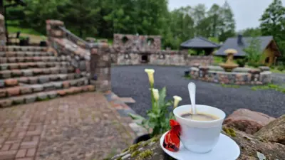 a cup of coffee sitting on top of a table at Namukas su ežero pakrante Trakai ,Viesų vila in Salkininkai