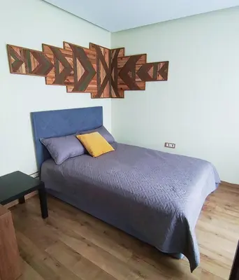 a bedroom with a bed with a wooden head board at Apartments Franny's Bees in Vilnius