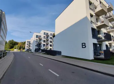 an empty street next to a white building at Apartments Franny's Bees in Vilnius