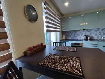 a kitchen with a table with an american flag on the wall at Apartments Franny's Bees in Vilnius
