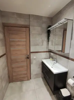 a bathroom with a sink and a mirror and a door at Apartments Franny's Bees in Vilnius