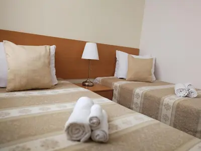 a hotel room with two beds with towels on them at Hotel Angelas in Utena