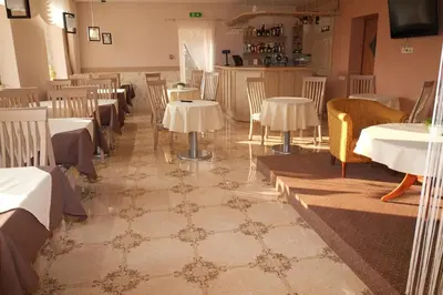a dining room with tables and chairs in a room at Hotel Angelas in Utena