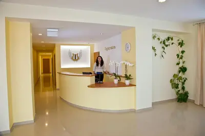 a woman standing at a counter in a hospital lobby at Hotel Angelas in Utena