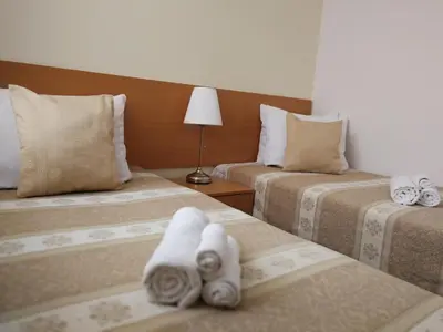 a hotel room with two beds with towels on them at Hotel Angelas in Utena