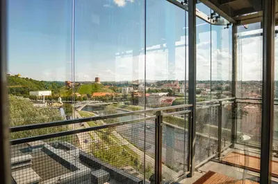 a view of a city from a building with glass windows at Vilnius city best view apartments in Vilnius
